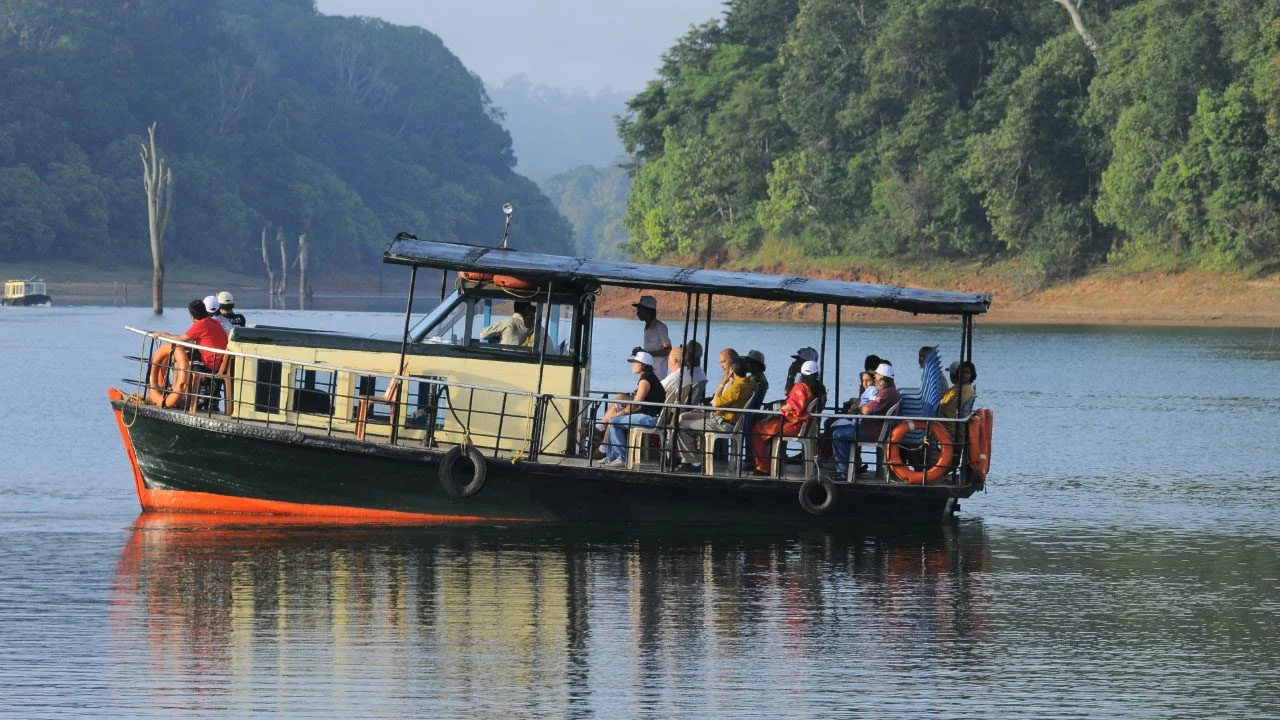 Thekkady boat ride on Periyar Lake surrounded by lush forests and wildlife scenery in Kerala